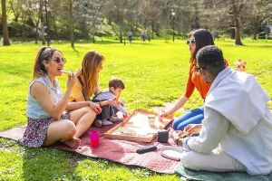 Friends and family gathering for a picnic in a sunny park
