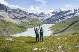 Two friends throwing yellow hats in the air