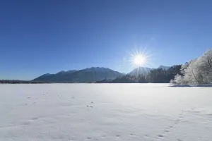 Frozen lake Barmsee with Karwendel mountainrange on morning with sun in winter