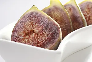 Category Historic EN Prints: Fruit, Figs Ficus Carica Anjir two cut in four halve kept ins shape white plate on white background