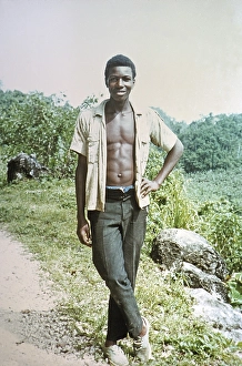 Full-length portrait of a young man with open shirt showing his chest, rural location, Jamaica, 1970, Central America