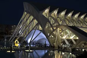 Futuristic architecture lit at night with reflections on water