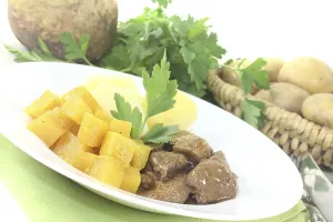 Game goulash with turnips on a light-coloured background