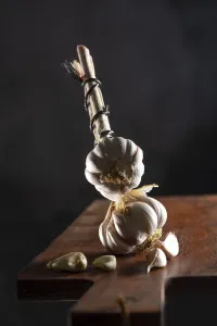 Garlic bulbs on wooden board, dark background