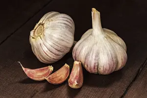 Garlic and cloves on old wooden background