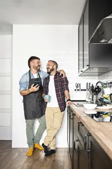 A gay couple standing close in a modern kitchen