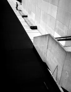 Geometric black and white scene with sharp shadows and a solitary person against a wall in Toronto