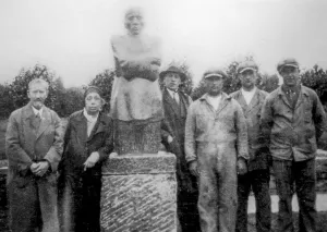 German artist Kaethe Kollwitz posing with husband in front of sculpture group The Grieving Parents