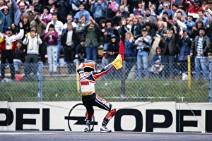 The German Waldi Ralf Waldmann, Team Schuh, Zwafink, Honda, 125 cc, celebrates his first Grand Prix victory with the German flag in front of the fans at the Motorcycle World Championship at the Hockenheimring on 26 May 1991 in Germany