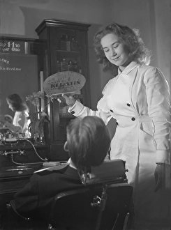 Getting a shave in the 1940s. A young woman in a barber shop