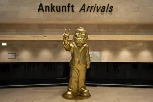A giant golden garden gnome greets travelers