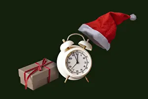 Gift, alarm clock, Santa hat on a green background