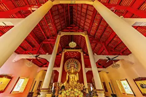Gilded Buddha statue in a public prayer hall in the Wat Phra Singh Buddhist temple complex