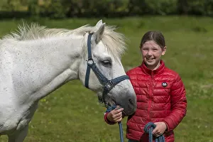 Girl, 10 years, with her horse in the pasture