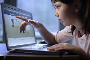 Girl, 10 years, with laptop, on Facebook web page