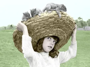 Girl with chipmunks sitting on her straw hat