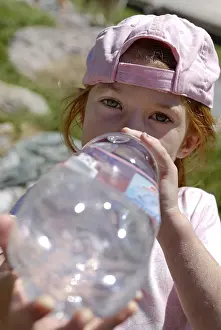 Girl drinking thurstily from a big water bottle