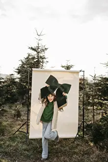 Framed Print : Girl holding green stitch standing in front of beige studio background in nature