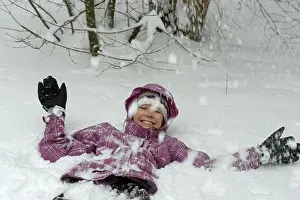 Girl lying in the snow in winter