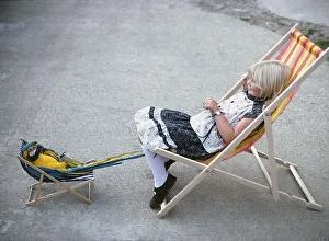 Girl with parrot in deck chair
