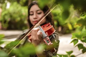 Girl with her violin playing a melody outdoors