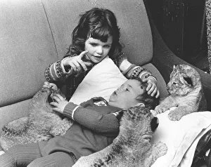 Girls and boys play with baby lions