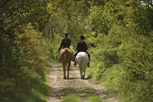 Two girls on horseback on an idyllic country lane