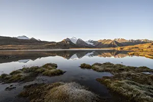 Glaciated mountain peaks reflected in a mountain lake at sunset