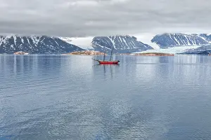 Glacier, mountains and sailing ship in a cloudy day in Svalbard islands