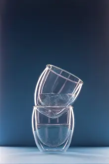 Two glasses with water on a blue background with copy space