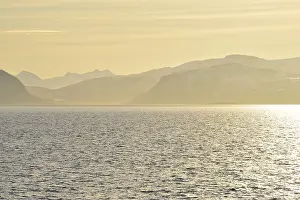 Glistening water and the mountains of Hinnoya in the yellow morning light