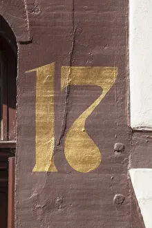 Golden house number plate number seventeen on a half-timbered house in the old town centre