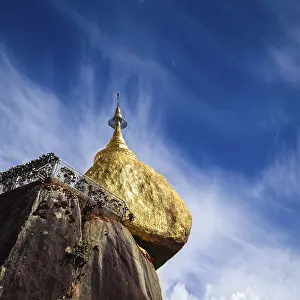 Golden Rock with row of traditional wind bells under blue sky