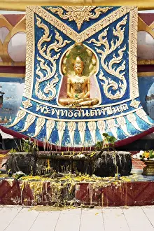 Golden statue of Buddha in meditation (Thursday) with offerings in Wat Phra Yai Temple