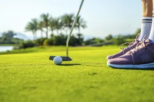 Golfer putting ball on a green using a putter
