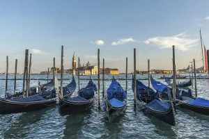 Gondolas moored at sunset with the island of san giorgio maggiore in the background