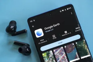 Google Earth app open on a phone with earbuds on a blue background