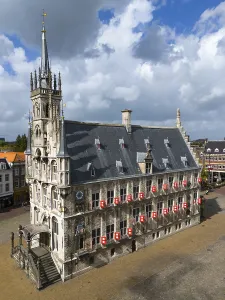 Gothic town hall in a city centre with characteristic architecture and cloudy sky