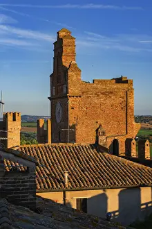 Gradara, Italy - August, 25, 2022: sunset view of clock tower and rooftops in gradara castle