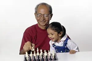 Grandfather and Granddaughter playing chess