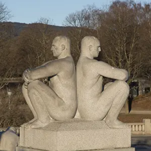Granite sculpture, two men sitting back to back