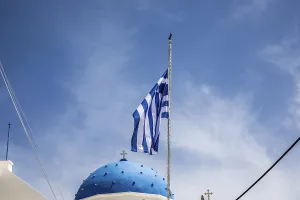 Greek flag waving in the wind, blue church dome