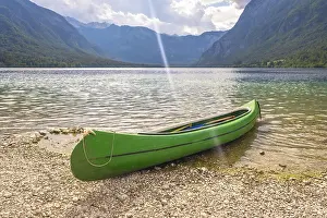 Category Mountain Landscapes Prints: Green canoe resting on the pebbled shore of lake bohinj