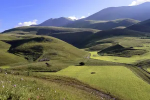 Green, hilly landscape under a clear blue sky