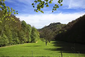 Framed Print : Green meadow in Bad Urach, surrounded by trees and hills under clear skies