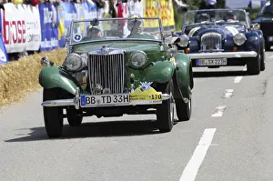 A green MG vintage car at a road race