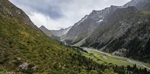 Green mountain valley with river and steep mountain peaks