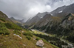 Green mountain valley with river and steep mountain peaks