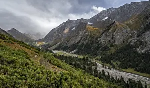 Green mountain valley with river and steep mountain peaks