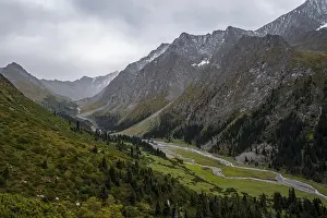 Green mountain valley with river and steep mountain peaks